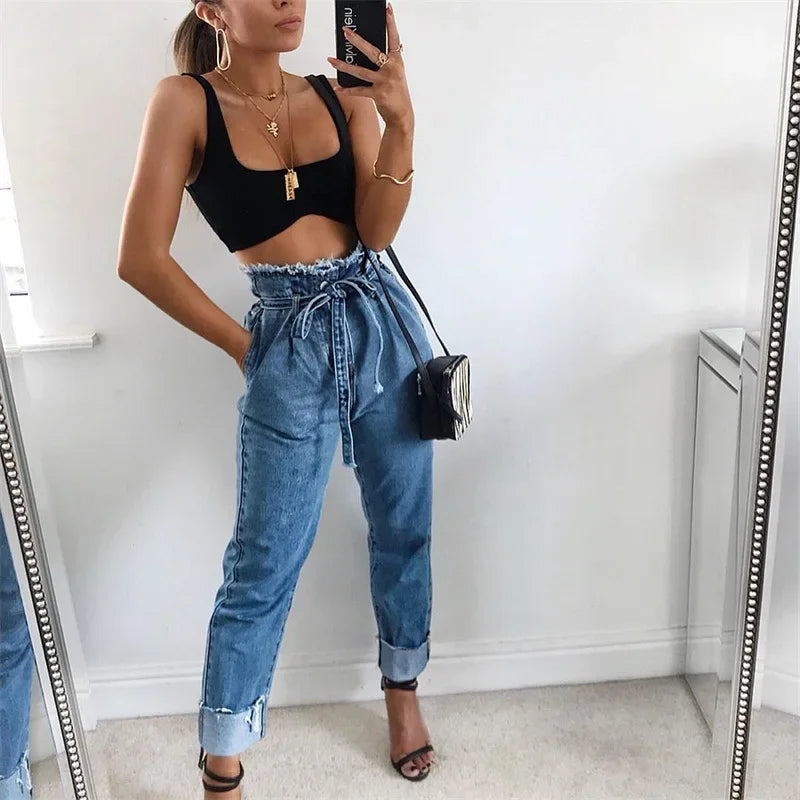 Woman wearing blu high-waist stretch jeans with rolled cuffs